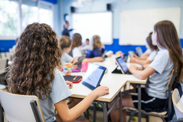 Multiple children sitting in a classroom.