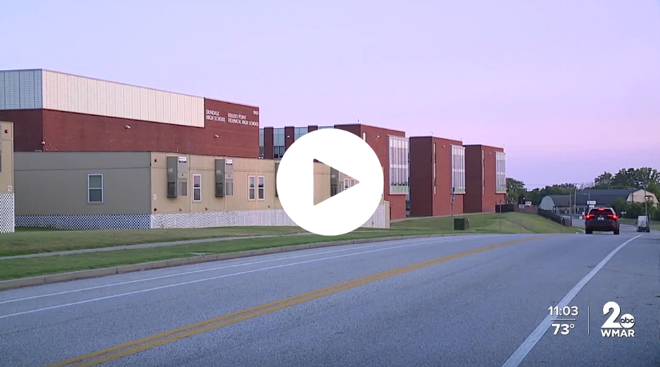 This photo shows the side of a school building and a road.