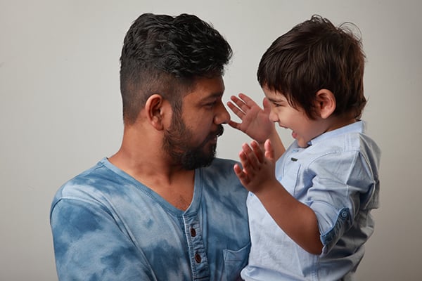 young father holding and smiling at his son